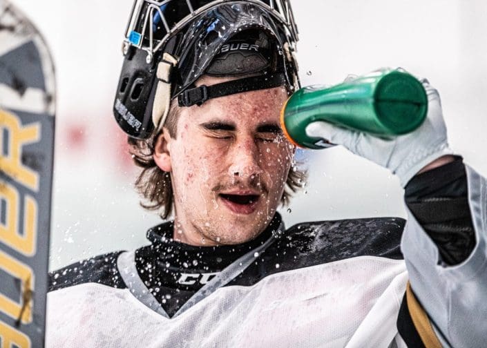 OAKVILLE, ON – NOV. 22, 2023: Milton Menace goalkeeper sprays himself with water before the start of the first period against the Oakville Blades.